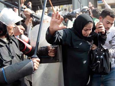 Một phụ nữ tìm cách thoát khỏi đám đông khi cảnh sát chống bạo động đụng độ người biểu tình