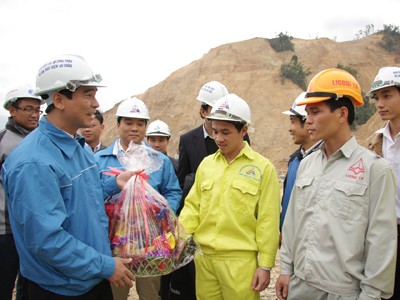 Anh Dương Văn An (trái) tặng quà, trao đổi với thanh niên công nhân Lai Châu tại công trường