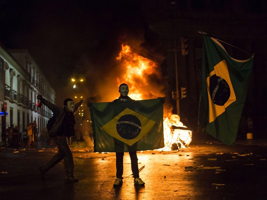 Một người biểu tình cầm cờ Brazil ở Rio de Janeiro hôm 17/6