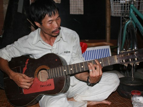 Người đàn ông nghèo với cây đàn guitar giúp dân xóm trọ ổ chuột vơi nhọc nhằn sau ngày làm việc. Ảnh: V.T.