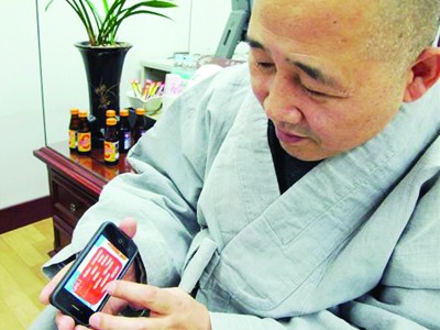 Hòa thượng Jung Ho đang mở một ứng dụng về triết lý Phật giáo trên điện thoại di động