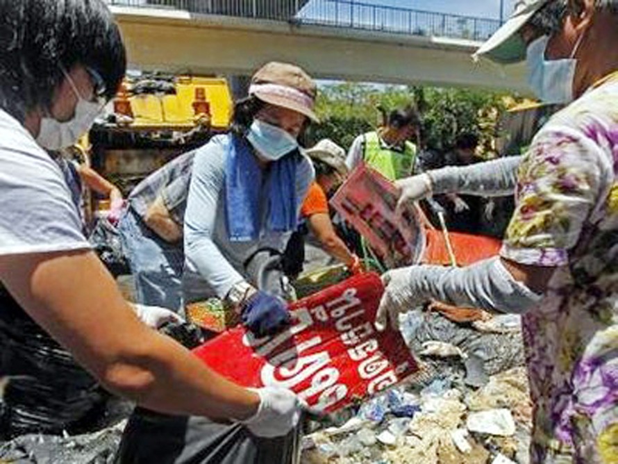 Những người tình nguyện tham gia dọn dẹp con đường từng bị phe áo đỏ chiếm giữ trong nhiều ngày qua tại thủ đô Bangkok