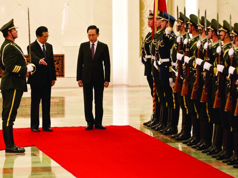 Chủ tịch quốc hội Hồ Cẩm Đào (trái) mời Tổng thống Lee Myung-bak duyệt đội danh dự tại lễ đón. Ảnh AP