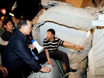 Thủ tướng Trung Quốc Ôn Gia Bảo (đeo kính) nói chuyện với những người bị vùi do bệnh viện sập trong trận động đất giữa tháng 5-2008 tại tỉnh Tứ Xuyên. Ảnh: China Daily
