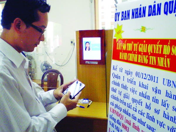 Kiểm tra lại số thứ tự giải quyết thủ tục hành chính qua tin nhắn tại UBND quận 1, TP Hồ Chí Minh. Ảnh: Huy Thịnh.