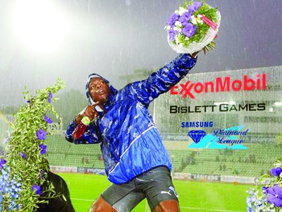 Usain Bolt ăn mừng chiến thắng dưới mưa Ảnh: AP