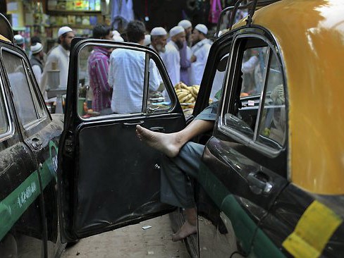 Một tài xế taxi chờ khách ở New Delhi, Ấn Độ