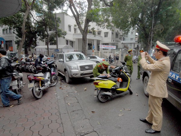 Lực lượng chức năng tiến hành ghi hình những điểm trông giữ xe bị thu hồi Giấy phép. ảnh chụp lúc 14 giờ 30 ngày 15-2 trên phố Quang Trung