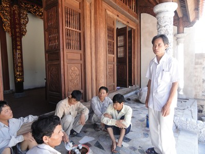 Anh Bảy (đứng) chỉ đạo thợ hoàn thiện ngôi đền thờ Bác Hồ
