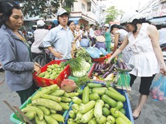 Người tiêu dùng mua rau quả với giá cao ở một chợ lề đường quận 7 (TP.HCM) chiều 21-12. Ảnh: Bạch Dương (Thanh Niên)