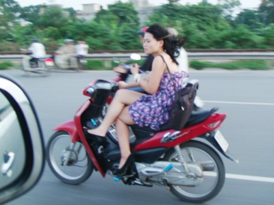 Thiếu nữ vắt chân chữ ngũ... đi xe máy