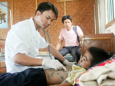 Trung tá, bác sỹ Đào Xuân Huế của Đoàn sản xuất 825 khám bệnh cho cháu nhỏ ở xã Mường Và Ảnh: Hải Giang
