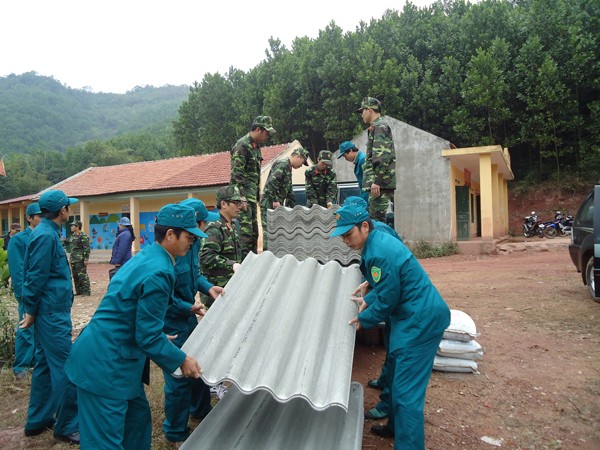 Cán bộ, chiến sỹ vận chuyển vật liệu đến thi công nhà vệ sinh cho các hộ dân bản