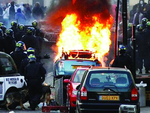 Cảnh sát chống bạo động đối phó tình trạng đốt xe ở London. Ảnh: BBC