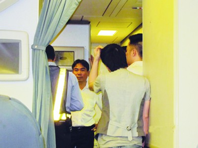 Ca sĩ Quang Hà (tay gãi đầu) đứng trong khoang thương gia Ảnh: Eileen Tan (người Singapore)