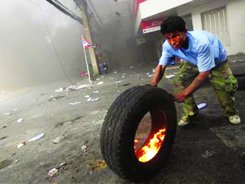 Một người biểu tình đốt lốp xe ngăn binh lính