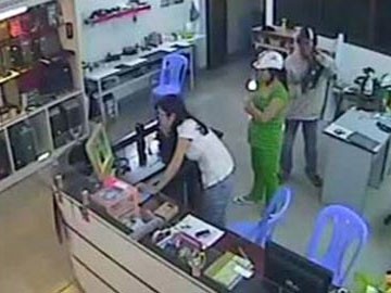 Người phụ nữ mặc đồ xanh đã che chắn cho người đàn ông thực hiện hành vi trộm cắp chiếc laptop của cửa hàng. (Ảnh từ camera: CAND)