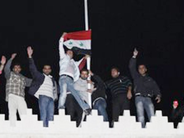 Những người ủng hộ ông Assad giương cờ Syria tại Đại sứ quán Qatar. Ảnh: Getty Images