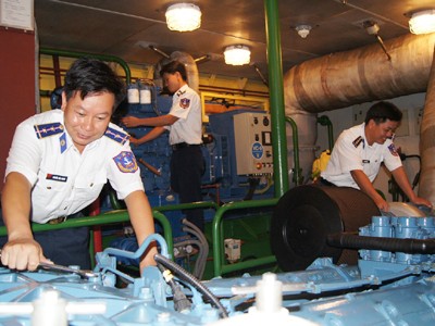 Trung úy Thạnh (trái) kiểm tra máy trước khi tàu khởi hành Ảnh: Ng.Minh
