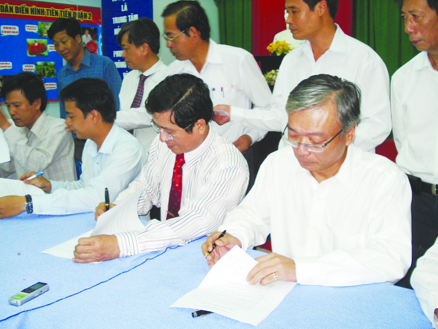 Tổng Giám đốc Vedan Yang Kun Hsiang (ngồi ngoài cùng bên phải) ký thỏa thuận với đại diện 839 hộ dân huyện Cần Giờ Ảnh: MN
