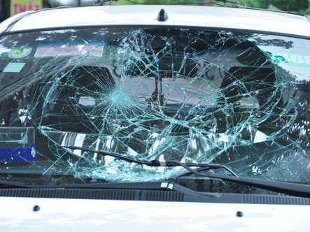 Mặt kính chiếc xe bị vỡ rạn sau khi đâm cảnh sát giao thông và xe ôm