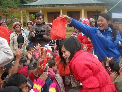 Thành viên CLB Tình nguyện trẻ chia quà cho em nhỏ xã Hua Bum