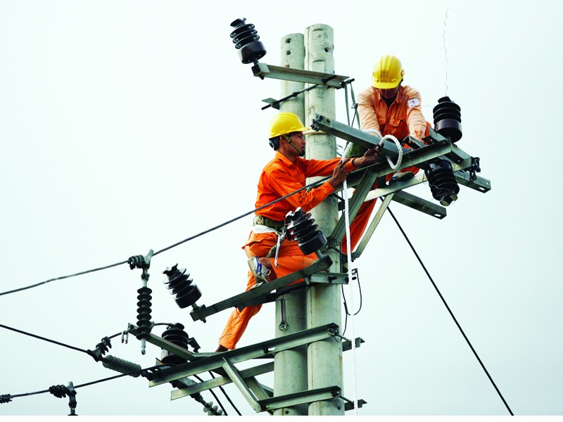 Công nhân điện lực đang thi công mạng lưới điện tại cầu Vĩnh Tuy (Hà Nội). Ảnh: Xuân Phú