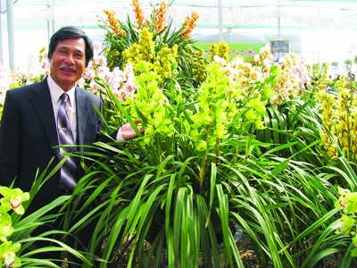 Nghệ nhân Đoàn Văn Quỳnh bên sản phẩm hoa lan của mình. Ảnh: Kim Anh