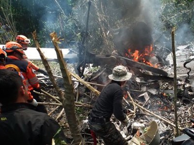Nhân viên cứu hộ quanh xác chiếc trực thăng Bell 212 rơi hôm 24-7. Ảnh: Reuters