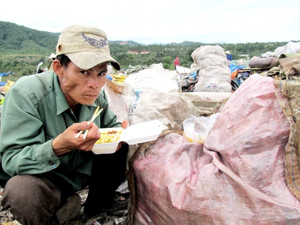 Anh Quang ăn mì trên bãi rác Ảnh: Nam Cường