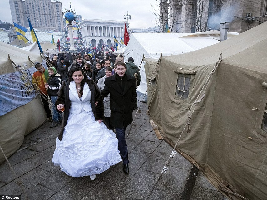 Cô dâu chú rể đi giữa những căn lều của người biểu tình ở Kiev, Ukraine hôm 21/12