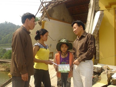 Đại diện đoàn cứu trợ trao quà cho gia đình chị Lê Thị Huệ