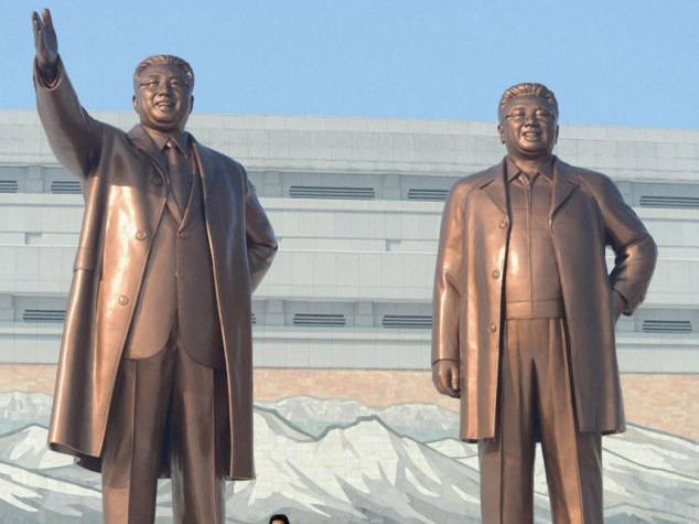 Tượng cố Chủ tịch Kim Jong Il (bên phải) trước khi thay áo