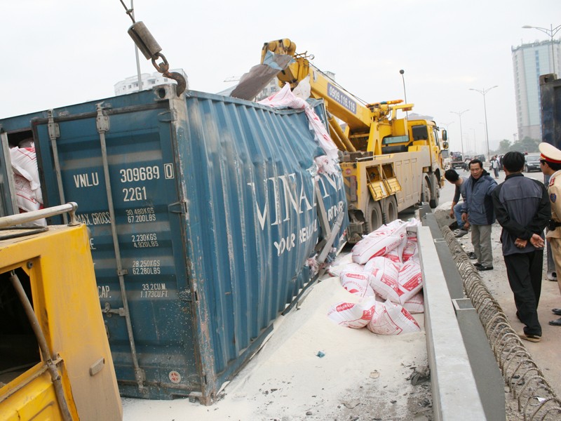 Xe container chở hàng chục bao tải gạo lật nhào
