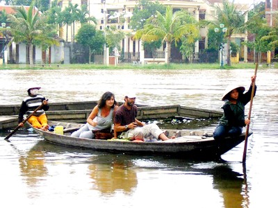 Ảnh minh họa: Một đôi nam nữ du khách nước ngoài cùng "thưởng ngoạn" cảnh nước lụt ở Hội An