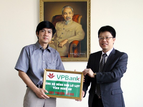 Tổng Giám đốc VP Bank Nguyễn Hưng (bên phải) trao cho TBT Đoàn Công Huynh số tiền 150 triệu đồng ủng hộ đồng bào bị lũ ở Nghệ An.