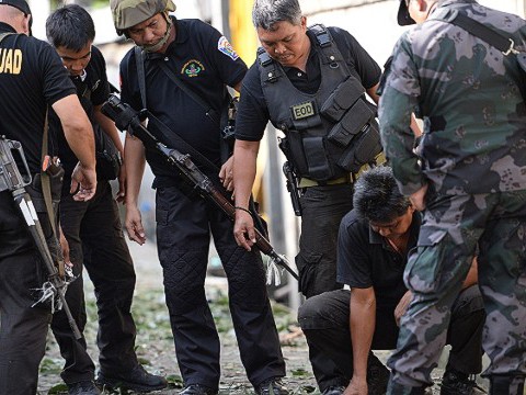 Cảnh sát và nhân viên rò bom mìn kiểm tra hiện trường vụ đánh bom xe xảy ra giữa cuộc đụng độ quân chính phủ và nổi dậy hôm 16/9