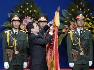 Chủ tịch nước gắn danh hiệu Anh hùng lực lượng vũ trang nhân dân lên lá cờ truyền thống của Lực lượng vũ trang Thành phố Hồ Chí Minh. (Ảnh: Thế Anh/TTXVN)