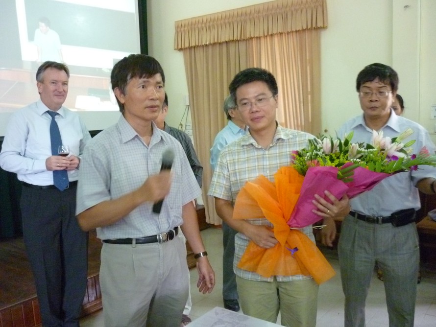 GS Ngô Bảo Châu nhận hoa chúc mừng của GS Lê Tuấn Hoa (trái)- Chủ tịch Hội Toán học Việt Nam.