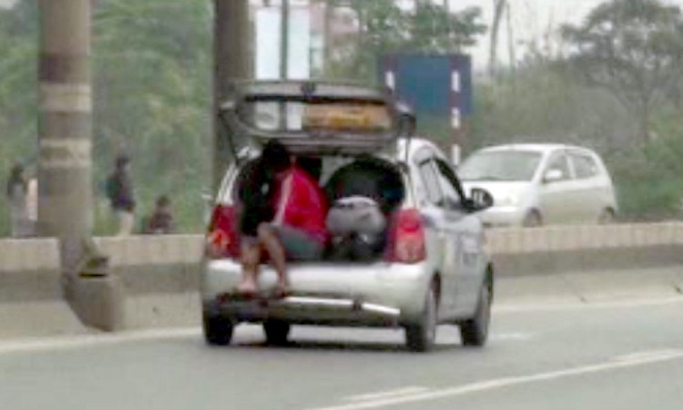 Hình ảnh 2 người ngồi trong cốp xe tại khu vực chân cầu Thăng Long