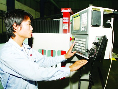 Công nhân điều khiển dây chuyền lắp ráp ô tô (tại Vinaxuki) Ảnh: Hồng Vĩnh
