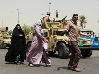 Người Iraq đi trên một con phố được kiểm soát an ninh chặt chẽ