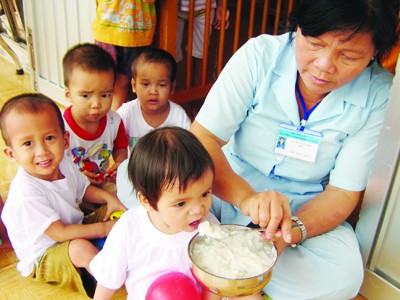 Hộ lý Dương Thị Hường chăm sóc trẻ bị bỏ rơi tại Trung tâm Ảnh: Kiến Giang