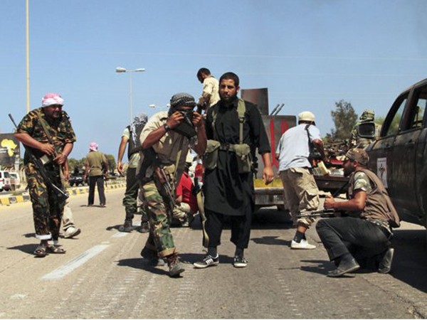Lính NTC tránh trọng pháo, rocket và tên lửa của quân Gadhafi hôm 24-9 ở Sirte. Ảnh: Gaia Anderson