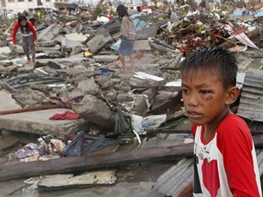 Em bé ngồi thẫn thờ giữa cảnh đổ nát hoang tàn sau siêu bão Hải Yến ở Philippines