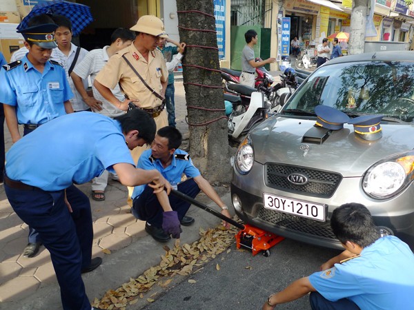 Cảnh sát giao thông và thanh tra GTCC xử lý ô tô đỗ sai nơi quy định. Ảnh: Hồng Vĩnh