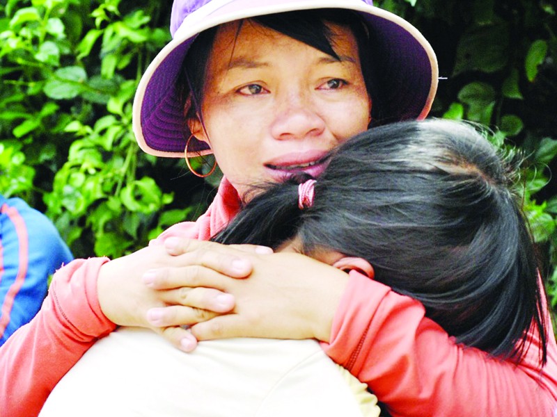 Chị Đào (áo trắng) khóc ngất khi hay tin chồng mất tích trong tâm bão số 1. Ảnh: Nguyễn Huy