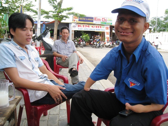 Toàn được tình nguyện viên Nay Droeng- cùng hoàn cảnh tật nguyền, hỗ trợ. Ảnh: Nguyễn Huy