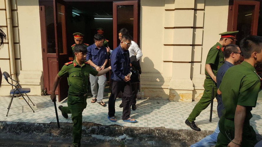 Dẫn giải 3 bị cáo về trại sau phiên tòa chiều 25/3. Ảnh: Văn Hào