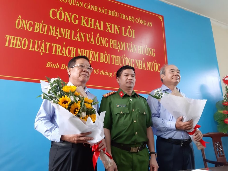 Thượng tá Đặng Trọng Cường tặng hoa cho ông Lân (trái) và Hướng (phải) tại buổi công khai xin lỗi. Ảnh: Tân Châu